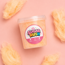 Top-down orange cotton candy tub and fluffy pieces on pale pink