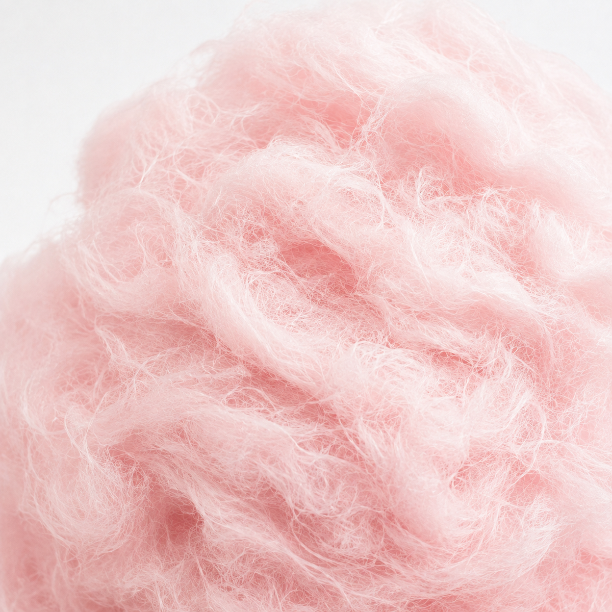Top-down pink vanilla cotton candy tub and fluffy pieces on pale pink