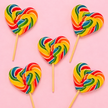 Top-down arrangement of rainbow heart lollipops on pale pink